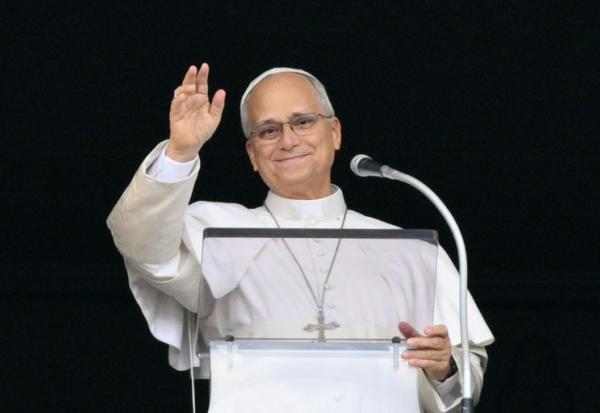 Le pape Léon XIV salue la foule depuis la fenêtre du palais apostolique, lors de la prière de l’Angélus, place Saint-Pierre, au lendemain de son retour au Vatican après une intervention chirurgicale, le 18 octobre 2026