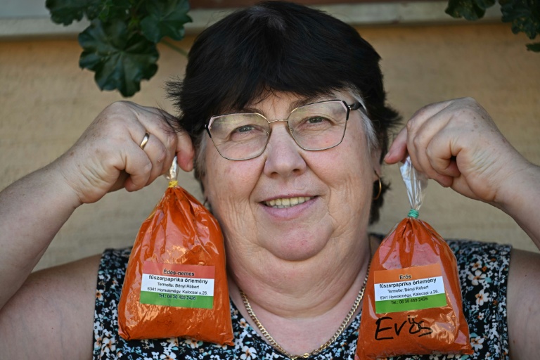 La cultivatrice Rozsa Benyi pose avec deux sachets de paprika devant son domicile à Homokmegy, dans le sud de la Hongrie, le 19 septembre 2026 