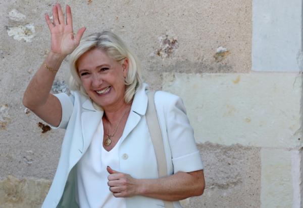 Marine Le Pen, cheffe du groupe parlementaire Rassemblement national (RN) et candidate à la présidentielle de 2027, salue ses sympathisants après une réunion de campagne à l'hôtel de ville de La Flèche, le 8 juillet 2026 dans la Sarthe