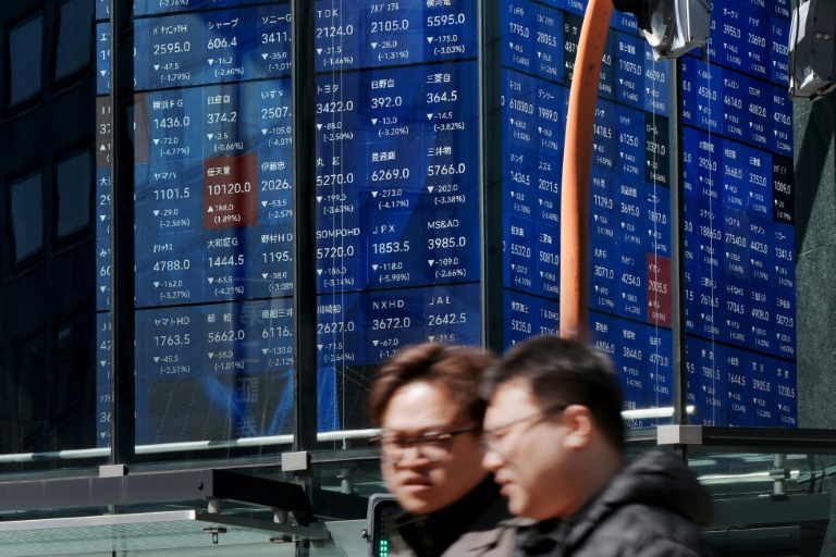 Un tableau d'affichage électronique indique les cours de l'indice Nikkei à la Bourse de Tokyo, le 12 mars 2026