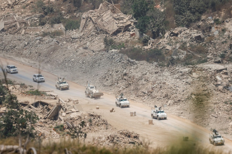 Des véhicules blindés de la Finul circulent au milieu de bâtiments détruits dans le sud du Liban, le 22 juillet 2026