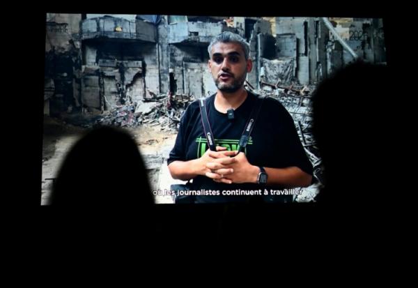 Le photographe palestinien Mahmoud Abu Hamda prononce un discours préenregistré, diffusé sur écran, après avoir reçu le prix du jury international de l'édition 2026 du Prix Bayeux Calvados-Normandie des correspondants de guerre, à Bayeux, le 10 octobre 2026