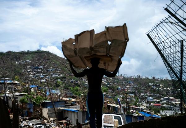 Un homme transporte des matériaux pour reconstruire sa maison à Mamoudzou, à Mayotte, le 2 janvier 2025