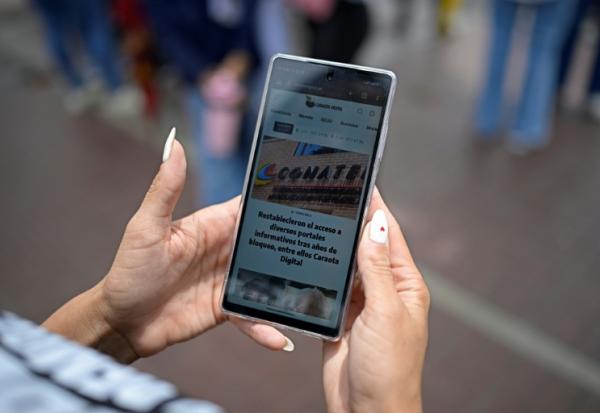 Une femme lit un article du site vénézuélien Caraota Digital à Caracas, le 17 septembre 2026