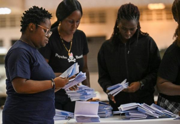 Les membres du personnel électoral vérifient les bulletins de vote lors du dépouillement dans un bureau de vote pendant les élections législatives à Paramaribo, le 25 mai 2025