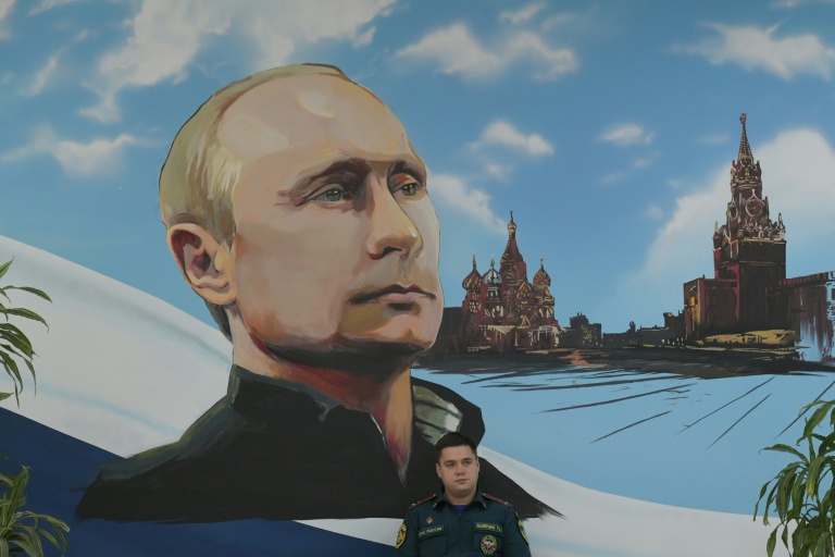 Un panneau mural représentant Vladimir Poutine et la Place rouge, le 20 septembre 2026 dans un bureau de vote de Donetsk, dans les territoires ukrainiens occupés par la Russie

