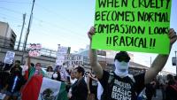 Des manifestants tiennent des pancartes et des drapeaux lors d'une manifestation contre la politique migratoire de Donald Trump, le 12 juin 2025 à Los Angeles