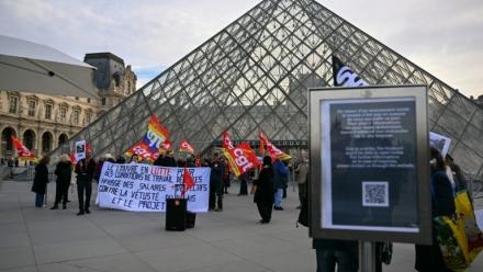 Des membres du syndicat CGT manifestent devant l'entrée du Louvre, à Paris, le 15 décembre 2025