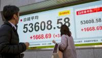 Des passants devant un panneau électronique affichant les cours du Nikkei 225 à la Bourse de Tokyo, le 13 janvier 2026. 