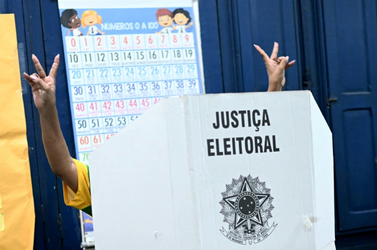 Une électrice fait un signe de victoire dans l'isoloir lors du second tour de la présidentielle brésilienne, le 25 octobre 2026 à Rio de Janeiro