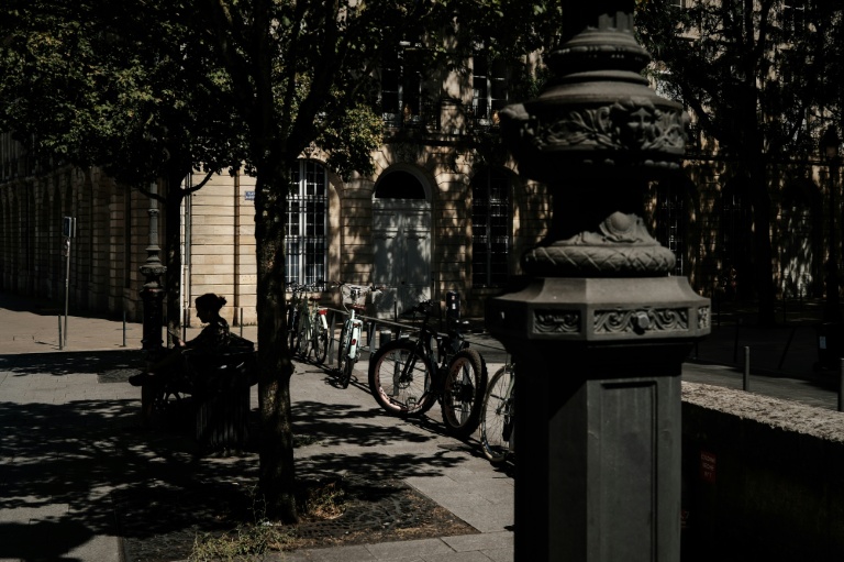 Une femme assise sur un banc à l'ombre à Bordeaux, le 6 juillet 2026 lors d'une vague de chaleur en France