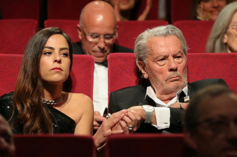 L'acteur français Alain Delon (d) tient la main de sa fille, l'actrice française Anouchka Delon, lors du 72e Festival de Cannes, le 19 mai 2019
