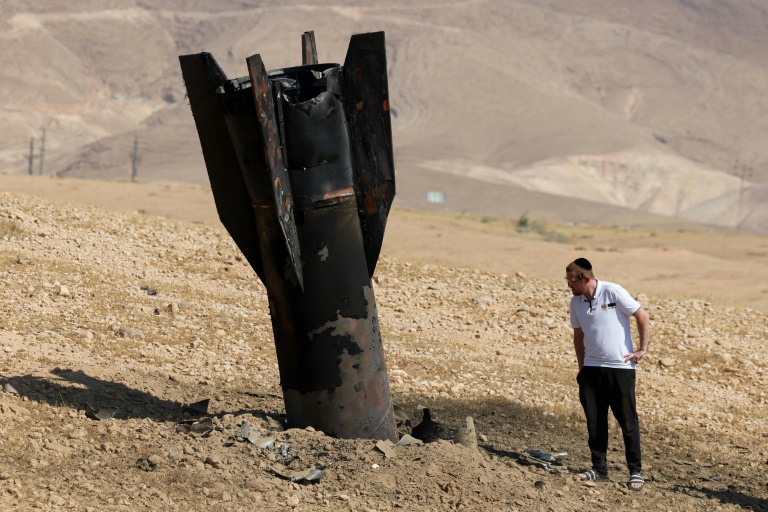 Un Israélien inspecte un missile tombé, à moitié enfoui dans le sol, en périphérie de Jéricho en Cisjordanie, le 8 juin 2026