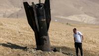 Un Israélien inspecte un missile tombé, à moitié enfoui dans le sol, en périphérie de Jéricho en Cisjordanie, le 8 juin 2026