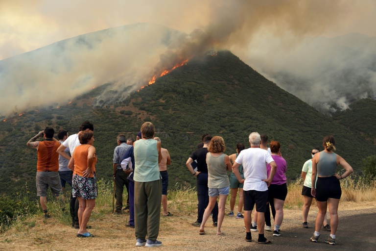 Des habitants observent un incendie de forêt à Castrillo de Cabrera, dans le nord-ouest de l'Espagne, le 16 août 2025