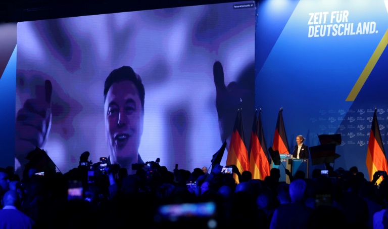 Elon Musk apparaît sur un écran lors d'une réunion du parti d'extrême droite allemand AfD, le 25 janvier 2025 à Halle