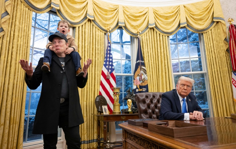 Elon Musk,, son fils sur les épaules à côté du président américain Donald Trump dans le Bureau ovale de la Maison Blanche, le 11 février 2025 à Washington