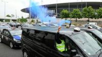 Des taxis allument des fumigènes lors d'une manifestation sur l'autoroute A1, le 21 mai 2025 à Saint-Denis