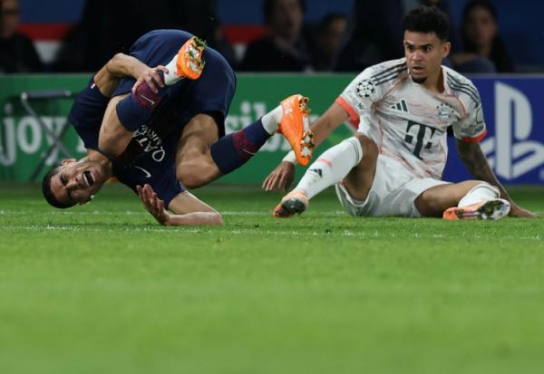 Le défenseur du Paris SG Achraf Hakimi (G) blessé lors de la défaite contre le Bayern Munich (2-1) à la suite d'un tacle de l'attaquant Luis Diaz (D), le 4 novembre 2025 au Parc des Princes