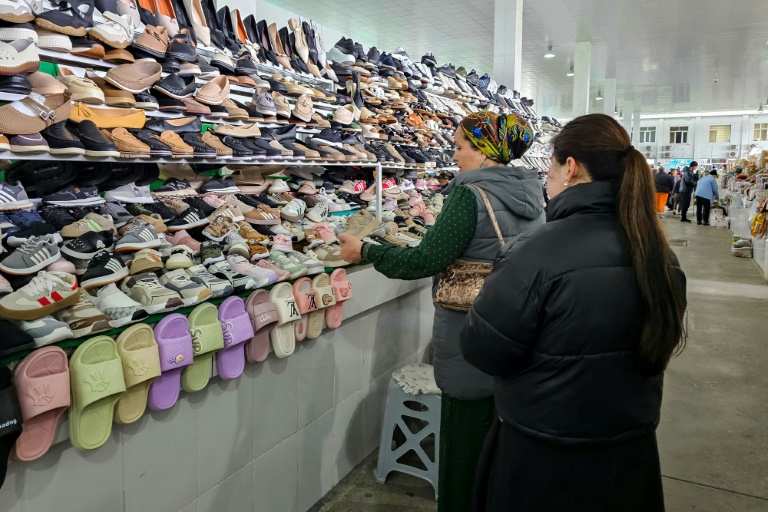 Une femme examine des chaussures fabriquées en Iran sur un marché d'Achkhabad, la capitale du Turkménistan, le 9 mars 2026