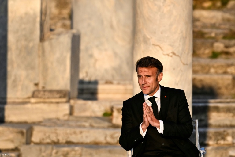 Le président français Emmanuel Macron salue le public à son arrivée sur scène lors d'un événement à l'Agora romaine d'Athènes, le 24 avril 2026 en Grèce