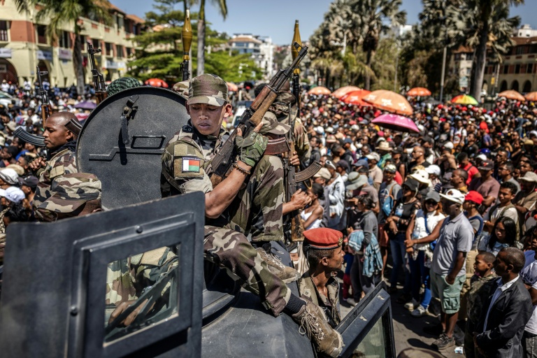 Des membres de l'unité militaire Capsat patrouillent à bord d'un véhicule blindé alors que les habitants se rassemblent pour une cérémonie en hommage aux manifestants tués lors des manifestations antigouvernementales à Antananarivo, le 12 octobre 2025 à Madagascar