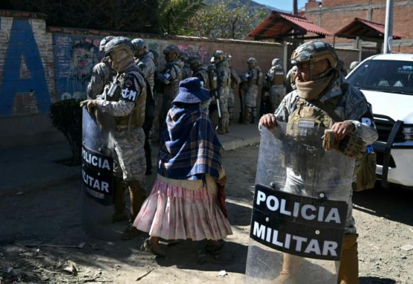 Des membres des forces de sécurité gardent une route après sa réouverture, auparavant bloquée par des manifestants exigeant la démission du président Rodrigo Paz,  le 5 juin 2026 à Carreras, dans le département de La Paz, en Bolivie