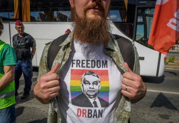 Un manifestant montre un portrait du Premier ministre hongrois Viktor Orban sur fond de drapeau LGBT+, imprimé sur son t-shirt, lors d'un rassemblement contre un projet de loi ciblant les médias et les ONG, le 1er juin 2025 à Budapest