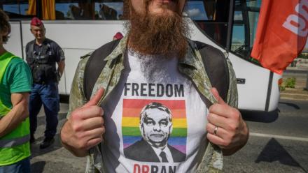Un manifestant montre un portrait du Premier ministre hongrois Viktor Orban sur fond de drapeau LGBT+, imprimé sur son t-shirt, lors d'un rassemblement contre un projet de loi ciblant les médias et les ONG, le 1er juin 2025 à Budapest