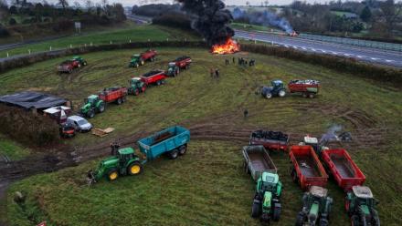 Des agriculteurs allument un feu alors qu'ils participent, avec leurs véhicules, à un blocage d'autoroute, à Poilley, dans l'ouest de la France, le 5 janvier 2026