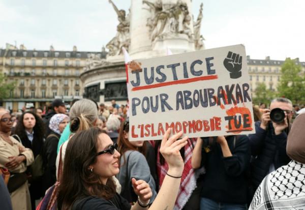 Un manifestant tient une pancarte lors d'un rassemblement en hommage à Aboubakar, le fidèle tué dans une mosquée à La Grand-Combe, et contre l'islamophobie, Place de la République à Paris le 27 avril 2025