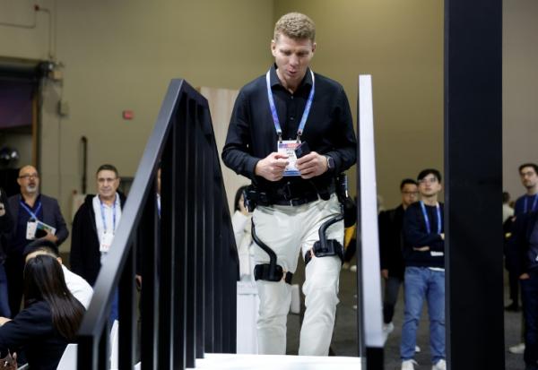 Un visiteur du salon de la technologie grand public CES essaie un exosquelette de Dnsys le 6 janvier 2026 à Las Vegas