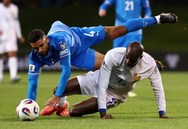L'Islandais Victor Palsson (en bleu) et le Français Jean-Philippe Mateta sont à la luute en match de qualifications pour le Mondial-2026, le 13 octobre 2025 à Reykjavik