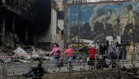 Des habitants passent devant un centre commercial endommagé à la suite des frappes russes à Kiev, le 25 mai 2026