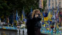 Des passants devant un mémorial improvisé pour les soldats ukrainiens et étrangers morts au combat, à Kiev le 7 octobre 2025