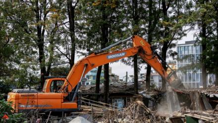 Une pelleteuse entame la démolition des bidonvilles abritant des milliers de personnes le long des berges de la capitale népalaise Katmandou, le 25 avril 2026