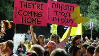 Des femmes brandissent des pancartes lors d’un rassemblement sur la place des Otages à Tel-Aviv, en Israël, avant la libération prévue de dizaines d'otages retenus dans la bande de Gaza, le 11 octobre 2025