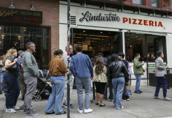 File d'attente devant L'industrie Pizzeria à New York le 15 mai 2026