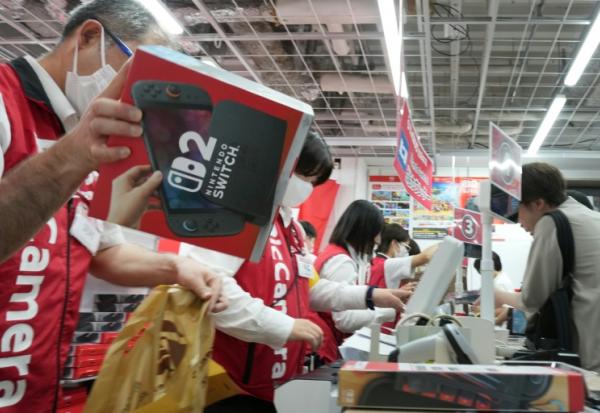 Des clients achètent la Nintendo Switch 2 dans un magasin d'électronique à Tokyo, le 5 juin 2025