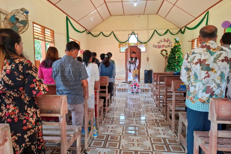 Des villageois assistent à la messe de Noël à l'église protestante d'Angkola, dans le village d'Aek Ngadol, le 25 décembre 2025, dans la province de Sumatra touchée par des inondations et glissements de terrain meurtriers, en Indonésie
