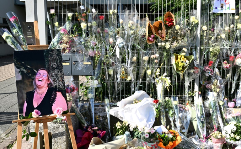 Une photo de Mélanie, la surveillante tuée par un élève, placée à côté des fleurs déposées devant les grilles du collège Françoise-Dolto, le 13 juin 2025 à Nogent, en Haute-Marne