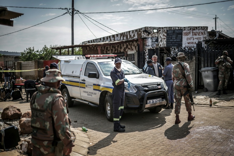 Des experts médicaux-légaux de la Force de défense nationale d'Afrique du Sud (SANDF) sur les lieux de la fusillade dans un bar de l'ouest de Johannesburg qui a fait 17 morts et 15 blessés, le 27 septembre 2026  