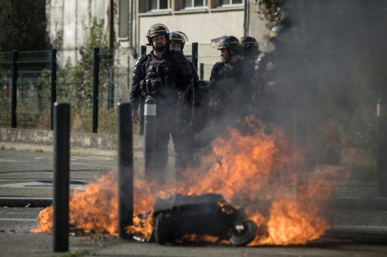 Des CRS près de poubelles en feu, lors d’une manifestation de lycéens devant le lycée Déodat à Toulouse, le 15 octobre 2026 en Haute-Garonne