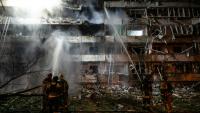 Des pompiers sur le site d'une frappe de missile russe contre un immeuble résidentiel à Kiev, le 14 octobre 2026 en Ukraine