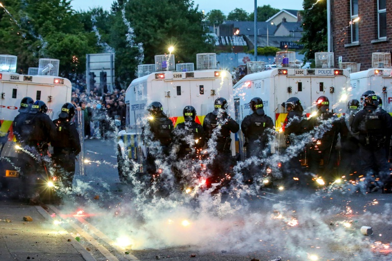 Des feux d'artifice lancés sur la police anti-émeute lors d'une troisième nuit de manifestations visant les immigrés à Ballymena, en Irlande du Nord, le 11 juin 2025
