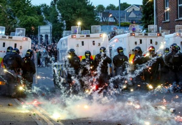 Des feux d'artifice lancés sur la police anti-émeute lors d'une troisième nuit de manifestations visant les immigrés à Ballymena, en Irlande du Nord, le 11 juin 2025