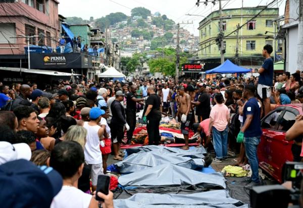 Des habitants se tiennent devant des corps alignés  dans une des favelas du Complexo da Penha, à Rio de Janeiro, le 29 octobre 2025