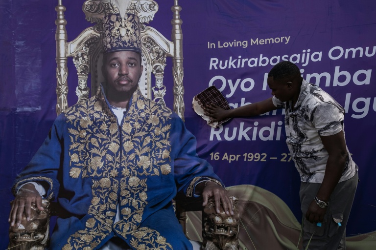 Une personne nettoie une affiche du défunt roi ougandais Oyo Nyimba Kabamba Iguru Rukidi IV au terrain de Humura, à Kyegegwa (Ouganda), le 4 septembre 2026