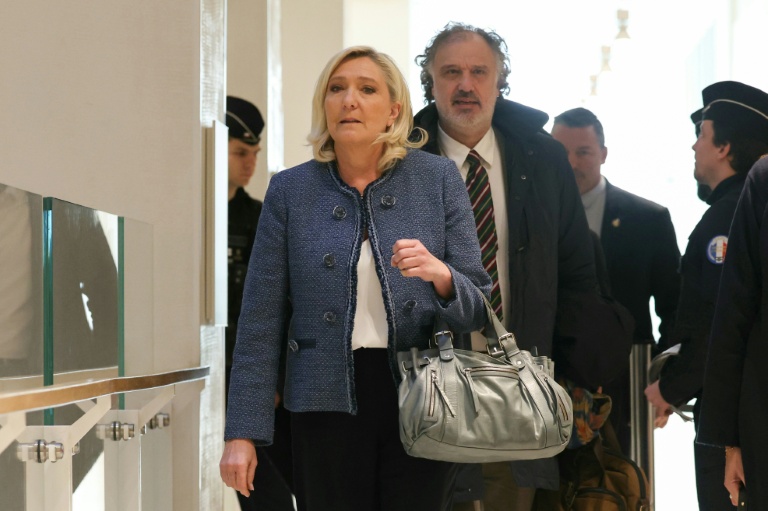 Marine Le Pen (g), présidente du groupe parlementaire du Rassemblement National (RN), arrive avec son avocat Rodolphe Bosselut au tribunal de Paris pour le verdict de son procès pour détournement présumé de fonds publics, le 31 mars 2025 à Paris