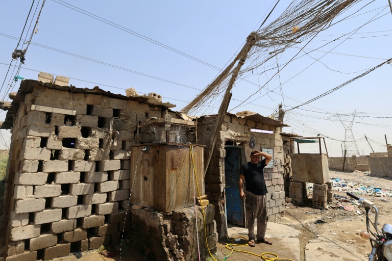 Un électricien fait une pause dans son travail sur un générateur, à Diwaniyah, dans le sud de l'Irak, le 10 août 2025